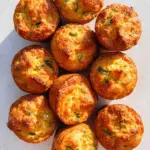 Cheesy sweet potato corn muffins displayed on a wooden platter