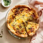 Homemade spinach mushroom quiche fresh out of the oven, garnished with herbs.