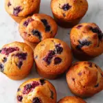 Freshly baked banana blackberry muffins on a rustic wooden table