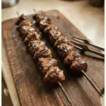 Delicious grilled heart skewers served on a platter with fresh herbs.