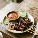 Delicious goat satay skewers served with spicy peanut sauce and fresh herbs.